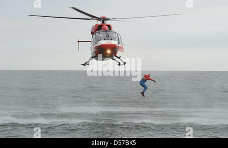 Ein Bademeister der Feuerwehr Greifswald springt aus dem Rettungshubschrauber der deutschen Rettungsflugwacht (DRF, deutsche Rettungsflugwacht) '' Christoph 47'' aus acht Metern Höhe in die Ostsee in der Nähe von Peenemünde, Deutschland, 4. Mai 2010. Vor der Ostsee Insel Greifswalder Oie Übungen für Seenot begann zu retten. Rettung Hubschrauber, das Schiff Wilhelm Kaisen, l Stockfoto