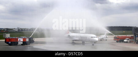 Ein Flugzeug der Fluggesellschaft Helvetic Airways wird mit einem Wasserbrunnen am Flughafen Rostock-Laage in Rostock, Deutschland, 6. Mai 2010 begrüßt. Die Flugverbindung zwischen Rostock und Zürich die donnerstags und sonntags betrieben wird ist die erste internationale Verbindung Flughafen Rostock nach innerdeutschen Verbindungen nach Köln, Stuttgart und München war bereits mit Stockfoto