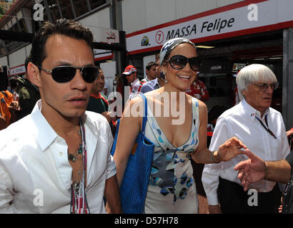 Formel 1 kommerzielle Supremo Bernie Ecclestone (R) führt Sängerin und Schauspielerin Jennifer Lopez (C) und ihr Ehemann Marc Anthony (L) durch das Gitter für die 2010 Formel 1 Grand Prix von Monaco in der Stadtkurs von Monte Carlo, Monaco, 16. Mai 2010 statt. Australiens Webber von Red Bull Racing gewann den begehrten Grand Prix vor deutschen Teamkollegen Vettel und Polens Kubica Renaul Stockfoto