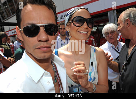 Formel 1 kommerzielle Supremo Bernie Ecclestone (R) führt Sängerin und Schauspielerin Jennifer Lopez (C) und ihr Ehemann Marc Anthony (L) durch das Gitter für die 2010 Formel 1 Grand Prix von Monaco in der Stadtkurs von Monte Carlo, Monaco, 16. Mai 2010 statt. Australiens Webber von Red Bull Racing gewann den begehrten Grand Prix vor deutschen Teamkollegen Vettel und Polens Kubica Renaul Stockfoto