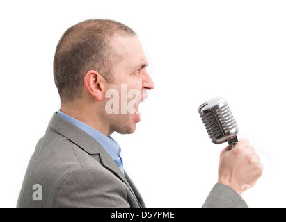 schreienden Mann mit einem Mikrofon. Der Mann ist europäischer Abstammung, im Profil und sehr wütend. Stockfoto