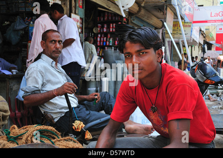 Junger Mann sitzend von der viel befahrenen Straße in Paharganj in Neu-Delhi Stockfoto