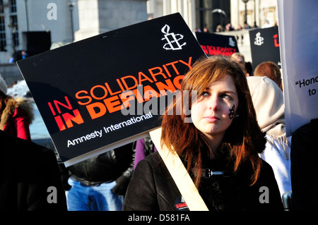 Eine junge Frau hält einen Banner auf einer Kundgebung auf dem Trafalgar Square, London, UK "in Solidarität in Defiance" lesen. Stockfoto