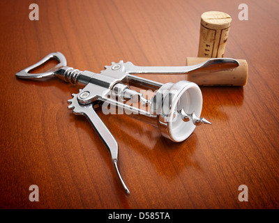 Korkenzieher und zwei Korken auf einem hölzernen Hintergrund. Stockfoto