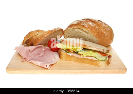 Sandwich und frisch gebackene Bloomer Brot mit Schinken und Tomaten auf einem Holzbrett isoliert gegen weiß Stockfoto