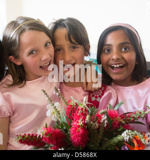 drei acht Jahre alten arabischen Mädchen feiern mit Blumen Stockfoto