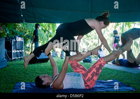 Bali, Indonesien-20. März 2013: Reihen von männlichen und weiblichen Erwachsenen, auf bunten Matten in einem Yoga-Kurs auf Bali Spirit Festival liegen. Stockfoto