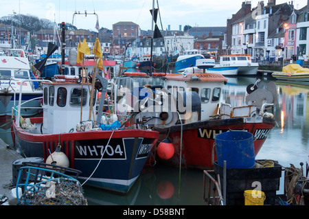 Englische Südküste Stadt am Meer. Bunte Fischerboote vertäut neben Custom House Quay im Hafen von Weymouth, Dorset, England, Vereinigtes Königreich. Stockfoto