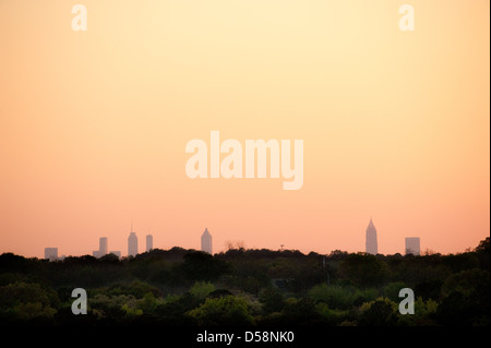 Die Skyline von Atlanta gebadet in das orange Leuchten des Sonnenuntergangs über dem bewaldeten Gelände von Stone Mountain Park gesehen. Stockfoto
