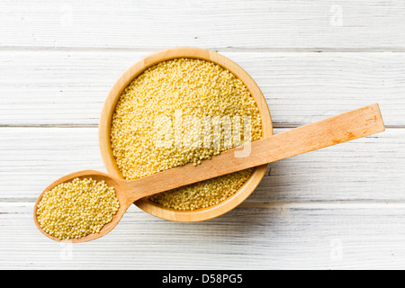 die Hirse in einem Holzlöffel Stockfoto