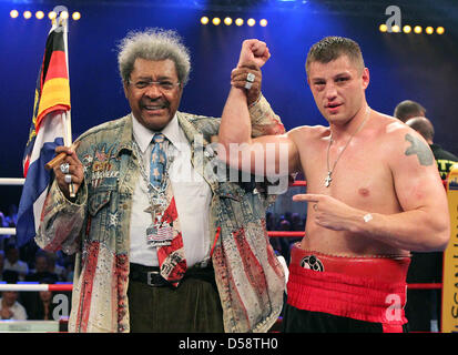 Belarussische Boxer Sergey Liakhovich (R) feiert seinen Sieg bei der Universum Champions Night Schwergewichts-Veranstaltung neben Box-Promoter Don King in Rostock, Deutschland, 22. Mai 2010. Liakhovich besiegte nicaraguanischer Boxer Evans Quinn (nicht abgebildet). Foto: Bernd Wuestneck Stockfoto