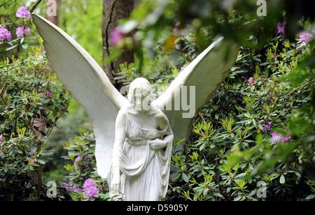 Eine Engelsfigur auf dem Ohlsdorfer Friedhof in Hamburg, Deutschland, 1. Juni 2010 abgebildet. Der Friedhof wurde als ein Landschaftspark von Wilhelm Cordes im Jahre 1877 auf 400 Hektar geplant. Zwei Buslinien bedienen auf 17 Kilometer auf dem Friedhof, der größte Grünfläche der Stadt ist. Bisher wurden einige 1,4 Millionen Beerdigungen. Foto: Maurizio Gambarini Stockfoto