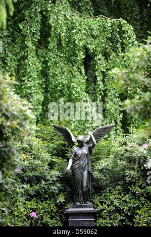 Eine Engelsfigur auf dem Ohlsdorfer Friedhof in Hamburg, Deutschland, 1. Juni 2010 abgebildet. Der Friedhof wurde als ein Landschaftspark von Wilhelm Cordes im Jahre 1877 auf 400 Hektar geplant. Zwei Buslinien bedienen auf 17 Kilometer auf dem Friedhof, der größte Grünfläche der Stadt ist. Bisher wurden einige 1,4 Millionen Beerdigungen. Foto: Maurizio Gambarini Stockfoto