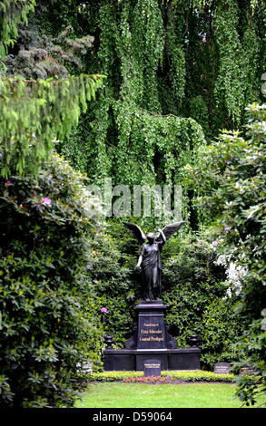 Eine Engelsfigur auf dem Ohlsdorfer Friedhof in Hamburg, Deutschland, 1. Juni 2010 abgebildet. Der Friedhof wurde als ein Landschaftspark von Wilhelm Cordes im Jahre 1877 auf 400 Hektar geplant. Zwei Buslinien bedienen auf 17 Kilometer auf dem Friedhof, der größte Grünfläche der Stadt ist. Bisher wurden einige 1,4 Millionen Beerdigungen. Foto: Maurizio Gambarini Stockfoto