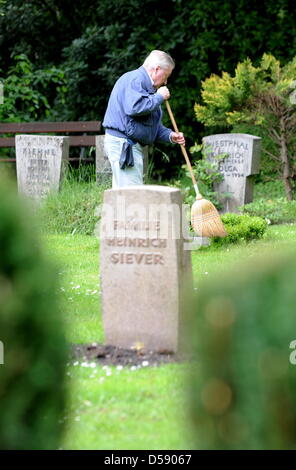 Ein Mann sorgt für ein Grab auf dem Ohlsdorfer Friedhof in Hamburg, Deutschland, 1. Juni 2010. Der Friedhof wurde als ein Landschaftspark von Wilhelm Cordes im Jahre 1877 auf 400 Hektar geplant. Zwei Buslinien bedienen auf 17 Kilometer auf dem Friedhof, der größte Grünfläche der Stadt ist. Bisher wurden einige 1,4 Millionen Beerdigungen. Foto: Maurizio Gambarini Stockfoto