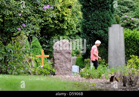 Eine Frau geht über den Ohlsdorfer Friedhof in Hamburg, Deutschland, 1. Juni 2010. Der Friedhof wurde als ein Landschaftspark von Wilhelm Cordes im Jahre 1877 auf 400 Hektar geplant. Zwei Buslinien bedienen auf 17 Kilometer auf dem Friedhof, der größte Grünfläche der Stadt ist. Bisher wurden einige 1,4 Millionen Beerdigungen. Foto: Maurizio Gambarini Stockfoto