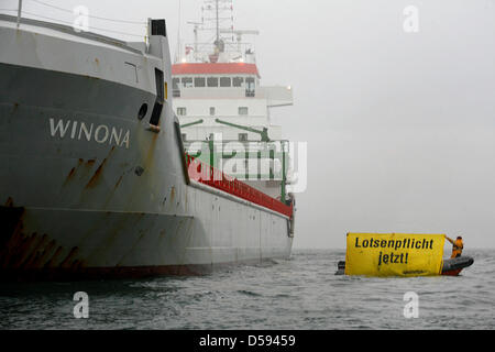 Der voll beladene Frachter "Winona" hat in der Ostsee in der Nähe der Insel Lolland, Dänemark, 11. Juni 2010 gestrandet. Der Durchschnitt der das Schiff beladen mit Stahl des Auftretens Platten in der Kadetrenden-Straße östlich von Gedser, Dänemark auf Verstand weg von Kiel, Deutschland, nach Sankt Petersburg, Russland. Greenpeace-Aktivisten in einem Schlauchboot fordern "Obligatorische Piloten, jetzt!" ("Lotsenpflicht Jetzt!") Fo Stockfoto