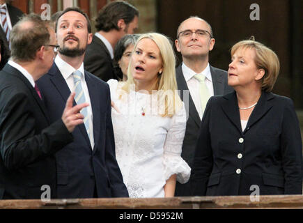 Pfarrer Hanns-Peter Neumann erklärt die Sehenswürdigkeiten Norwegens Kronprinz Haakon, seine Frau, Kronprinzessin Mette-Marit, Gouverneur von Mecklenburg-Vorpommern, Erwin Sellering und deutsche Bundeskanzlerin Angela Merkel (L-R) bei einem Besuch in der Kirche St. Nicolai in Stralsund, Deutschland, 12. Juni 2010. Norwegens Thronfolger und seine Frau kamen auf Einladung der Bundeskanzlerin Merkel in er Stockfoto