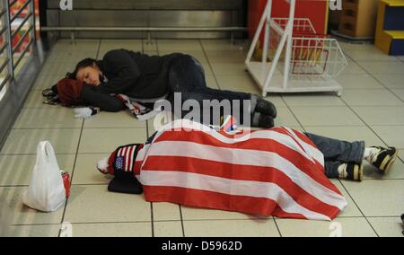 Touristen versuchen, etwas Schlaf zu bekommen, wie sie auf dem Boden an der Johannesburg Airport in South Africa 13. Juni 2010 liegen. Südafrika Gastgeber der FIFA WM 2010 vom 11. Juni bis 11 Juli zum ersten Mal auf afrikanischem Boden. Foto: Marcus Brandt Dpa +++(c) Dpa - Bildfunk +++ Stockfoto