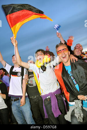 Zuschauer verfolgen Deutschlands Sieg in ihrem ersten Spiel bei FIFA WM 2010, da sie ein FIFA Fan Fest in Hamburg, Deutschland, 13. Juni 2010 teilnehmen. FIFA organisiert sogenannte Fan Fests nahe der ganzen Welt, kostenlose öffentliche Übertragung der FIFA World Cup 2010 bereitzustellen. Foto: ANgelika Warmuth Stockfoto