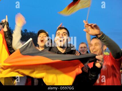 Zuschauer verfolgen Deutschlands Sieg in ihrem ersten Spiel bei FIFA WM 2010, da sie ein FIFA Fan Fest in Hamburg, Deutschland, 13. Juni 2010 teilnehmen. FIFA organisiert sogenannte Fan Fests nahe der ganzen Welt, kostenlose öffentliche Übertragung der FIFA World Cup 2010 bereitzustellen. Foto: ANgelika Warmuth Stockfoto