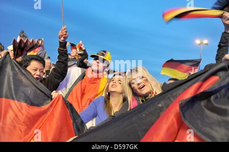 Zuschauer verfolgen Deutschlands Sieg in ihrem ersten Spiel bei FIFA WM 2010, da sie ein FIFA Fan Fest in Hamburg, Deutschland, 13. Juni 2010 teilnehmen. FIFA organisiert sogenannte Fan Fests nahe der ganzen Welt, kostenlose öffentliche Übertragung der FIFA World Cup 2010 bereitzustellen. Foto: ANgelika Warmuth Stockfoto