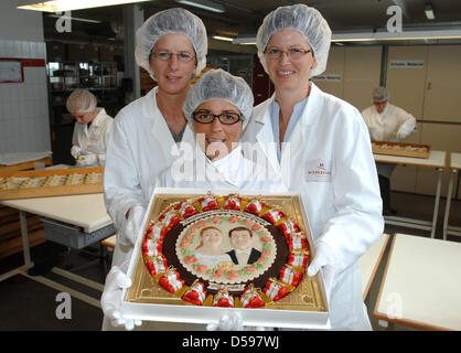 Die Modelliererinnen Nina Riedel (l) Und Christin Hentschel (r) Zeigen Zusammen Mit Konditorin Angela Hartmann bin Montag (14.06.2010) in LŸbeck sterben von Ihnen Hergestellte Niederegger Marzipantorte fŸr sterben am 19.06.. in Stockholm Stattfindende Hochzeit von Kronprinzessin Victoria Und Dem zukŸnftigen Prinz Daniel. Neben der Sogenannten Papsttorte (in Buchform) ist Die Kronprinzessin-V Stockfoto