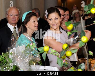 Kronprinzessin Victoria von Schweden (R), König Carl XVI. Gustaf von Schweden (L) und Königin Silvia von Sweden (C) schauen Sie sich die Geschenke, die sie im Rahmen eines Empfangs von der lokalen Regierung im Stockholmer Rathaus anlässlich der Hochzeit in Stockholm, Schweden, 18. Juni 2010 erhalten. Die Trauung statt findet am 19. Juni 2010. Foto: CARSTEN REHDER Stockfoto