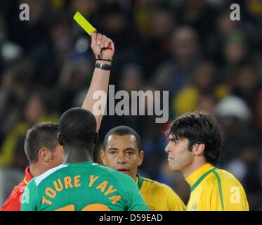 Französische Schiedsrichter Stéphane Lannoy (L) zeigt die gelbe Karte Brasiliens Kaka als Teamkollege Gilberto Silva und Côte d ' Ivoire Toure Yaya während des 2010 FIFA World Cup G Gruppenspiel zwischen Brasilien und der Elfenbeinküste im Soccer City Stadium in Johannesburg, Südafrika 20. Juni 2010 blicken auf. Foto: Achim Scheidemann Dpa - verweisen wir auf http://dpaq.de/FIFA-WM2010-TC +++(c) Dpa - Bildfunk +++ Stockfoto