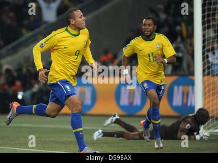 Brasiliens Luis Fabiano (L) feiert erzielte mit Teamkollege Robinho als Côte d ' Ivoire Torwart Boubacar Barry ausgetretenen liegt auf dem Boden während des 2010 FIFA World Cup G Gruppenspiel zwischen Brasilien und der Elfenbeinküste im Soccer City Stadium in Johannesburg, Südafrika 20. Juni 2010. Foto: Achim Scheidemann Dpa - entnehmen Sie bitte http://dpaq.de/FIFA-WM2010-TC Stockfoto