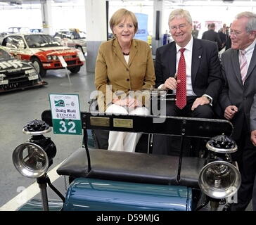 Bundeskanzlerin Angela Merkel (CDU) Und der Präsident von General Motors (GM) Europa Und Vorsitzende der Geschaeftsleitung der Adam Opel GmbH, Nick Reilly, einer bin Montag (28.06.10) in der Oldtimerwerkstatt von Opel in Rüsselsheim in Einem "Lutzmann" aus Dem Jahr 1899, Waehrend der Hessische CDU-Frationsvorsitzende Christean Wagner (r.) schon Steht. Sterben Fraktionvorsitzenden v Stockfoto