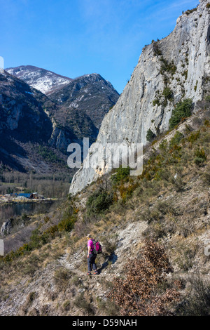 Weibliche Walker nähert sich Cliff, verschneiten Bergen Stockfoto