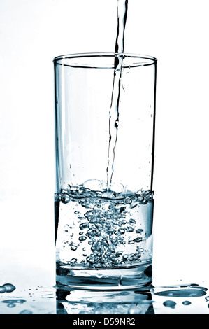 Kaltes Wasser in ein Glas gegossen wird. Stockfoto