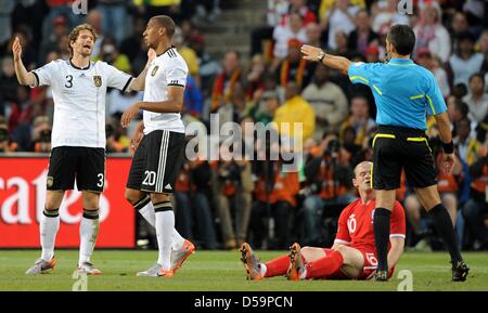 Deutschlands Arne Friedrich reagiert als Teamkollege Jerome Boateng zusieht, Englands Wayne Rooney sitzt auf dem Boden und uruguayische Schiedsrichter Jorge Larrionda Gesten während des 2010 FIFA World Cup Runde von sechzehn Match zwischen Deutschland und England im Free State Stadion in Bloemfontein, Südafrika 27. Juni 2010. Foto: Marcus Brandt Dpa - entnehmen Sie bitte http://dpaq.de/FIFA-WM2010-TC Stockfoto