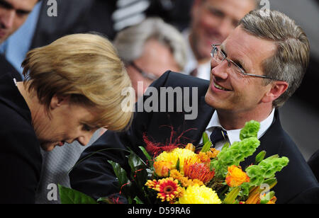 Bundeskanzlerin Angela Merkel präsentiert der neu gewählte Bundespräsident Christian Wulff mit Blumen in Berlin, Deutschland am 30. Juni 2010. Foto: Hannibal Stockfoto