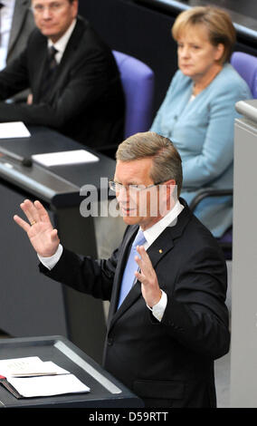 Neu geschworen in Präsident von Deutschland Christian Wulff (CDU) hält seine erste Rede im Bundestag in Berlin, Deutschland, 2. Juli 2010. Außenminister Guido Westerwelle (FDP) (L) und Bundeskanzlerin Angela Merkel (CDU) sind im Hintergrund sitzt. Die ehemaligen unteren sächsische Ministerpräsident Wulff war gewähltes Staatsoberhaupt am 30. Juni 2010 Wit Stockfoto