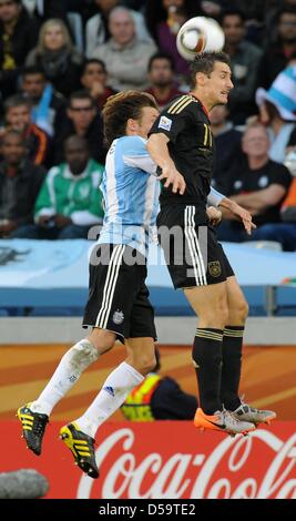 Deutschlands Miroslav Klose (R) wetteifert um den Ball mit Argentiniens Gabriel Heinze während des 2010 FIFA World Cup-Viertelfinalspiel zwischen Argentinien und Deutschland im Green Point Stadion in Kapstadt, Südafrika 3. Juli 2010. Foto: Marcus Brandt Dpa - verweisen wir auf http://dpaq.de/FIFA-WM2010-TC +++(c) Dpa - Bildfunk +++ Stockfoto