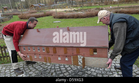 Mitarbeiter Mario Schönau (L) und Mario Fritsch (R) aufwachen das Modell von der Frosch-Mühle aus dem Winterschlaf im "Vorbeizuschauen" Miniatur City Park in der Umgebung von Eisenberg, Deutschland am 29. März 2010. Die Exposition von etwa 50 Miniatur-Gebäude auf der Ebene der 01:20, darunter zehn Modelle, die die Originale der alten Wassermühlen im Tal um 1900 gleichsetzen öffnet bei ea Stockfoto