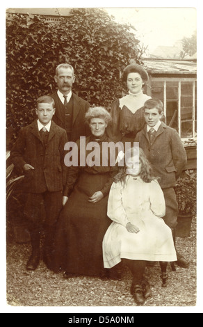 Postkarte-Porträt einer respektablen Edwardian Familie mit Oma in ihrem Garten, ca. 1905, U.K Stockfoto