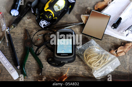 Abbildung - eine illustrierte Bild zeigt ein Geocacher, die seine Ausrüstung auf dem Boden in Dresden, Deutschland, 26. März 2013 ausgebreitet hat. Geocaching ist eine Art elektronische Schatzsuche mit GPS-Empfängern. Die geografischen Koordinaten des Caches werden ins Internet gestellt. Die Verstecke oder Geocaches sind in der Regel kleine Behälter mit einem Logbuch und kleine Gegenstände zum Tausch. Foto: Thomas Eisenhuth Stockfoto