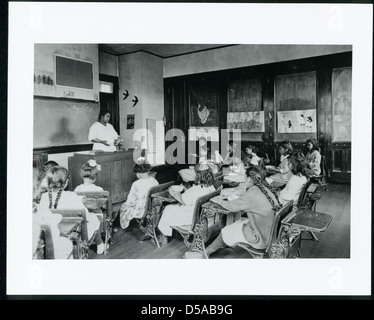 Dieses Foto zeigt indische Kinder in der Onondaga Reservation, die ein warmes Mittagessen genießen, Teil einer Zusammenarbeit zwischen Bildungseinrichtungen und Home Economics Programmen. Das Bild befindet sich in der Cornell University Library. Stockfoto