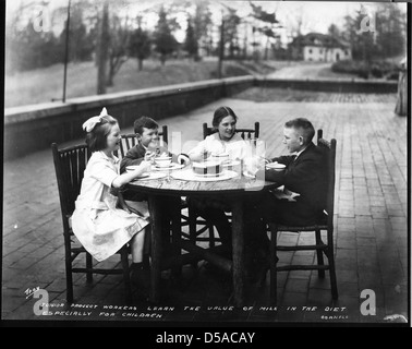 Ein Foto, das vier Kinder zeigt, die ein Essen auf einer Terrasse genießen, Teil eines Programms zur Hauswirtschaft. Dieses Bild zeigt die Bildungsaktivitäten des frühen 20. Jahrhunderts in den USA Stockfoto