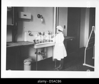 Dieses Bild ist Teil der Junior Extension Serie, in der gezeigt wird, wie Kinder bei Haushaltsaufgaben helfen können. Das Foto betont die pädagogischen Ansätze des frühen 20. Jahrhunderts in Bezug auf Familienrollen. Stockfoto