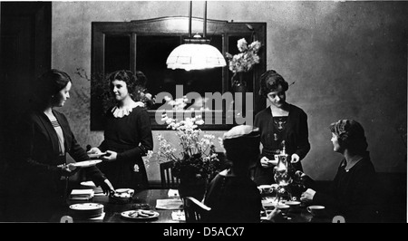 Dieses Foto zeigt einen Nachmittagstee in einer Wohnung, die Teil des Home Economics-Programms der Cornell University ist. Das Bild spiegelt den pädagogischen Ansatz der Hauswissenschaft und der Hausarbeit während des frühen 20. Jahrhunderts wider. Stockfoto