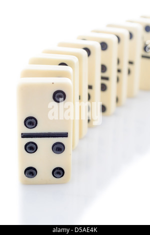 Reihe von Dominosteinen auf weißem Hintergrund Stockfoto