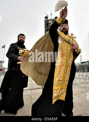 Ein russisch-orthodoxer Priester segnet Medienvertreter kurz nach der Segnung der Sojus-Rakete auf der Startrampe in Baikonur Kosmodrom 27. März 2013 in Kasachstan.  Start der Sojus-Rakete ist geplant für März 29 und schicken Expedition 35 Sojus-Besatzung auf eine fünf und eine Hälfte Monate Mission an Bord der internationalen Raumstation ISS. Stockfoto