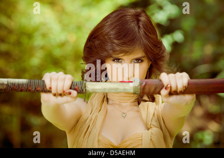 Frau mit Schwert im Wald Stockfoto