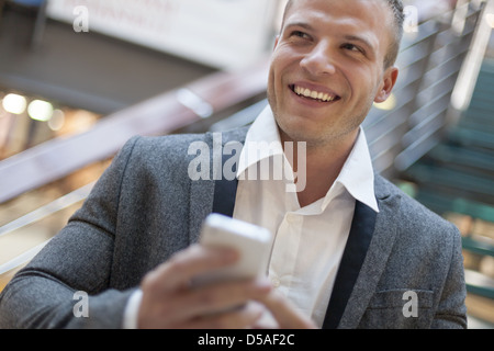 Männer mit Smart Telefon auf Seite der Hintergrund jedoch unscharf, Geschäftshaus Interieur Stockfoto