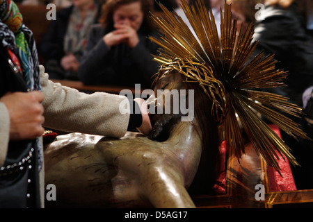 Menschen beten in der Nähe einer Statue repräsentiert Christus in einer Kirche in der Osterwoche in Spanien Stockfoto