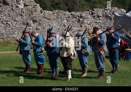Eine Gruppe von englischen Bürgerkrieg reenactors in die Uniformen der royalistischen Musketiere laden sie ihre Waffen zum Brennen bereit. Corfe Castle, Dorset, England, UK. Stockfoto
